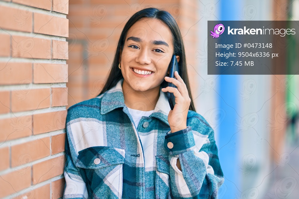 Young latin girl smiling happy talking on the smartphone at the city.