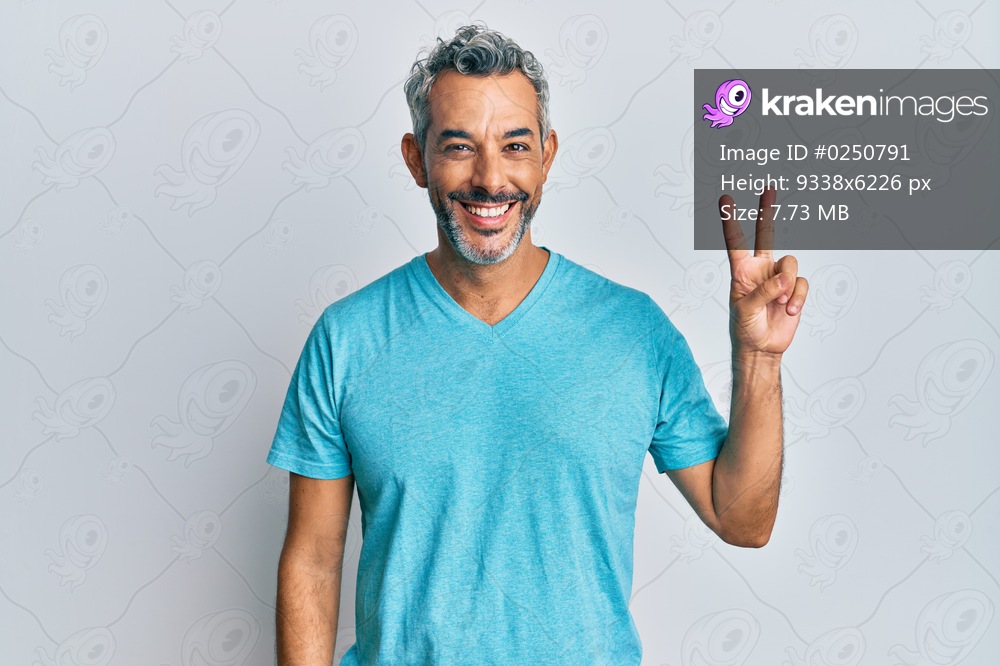 Middle age grey-haired man wearing casual clothes showing and pointing up with fingers number two while smiling confident and happy. 