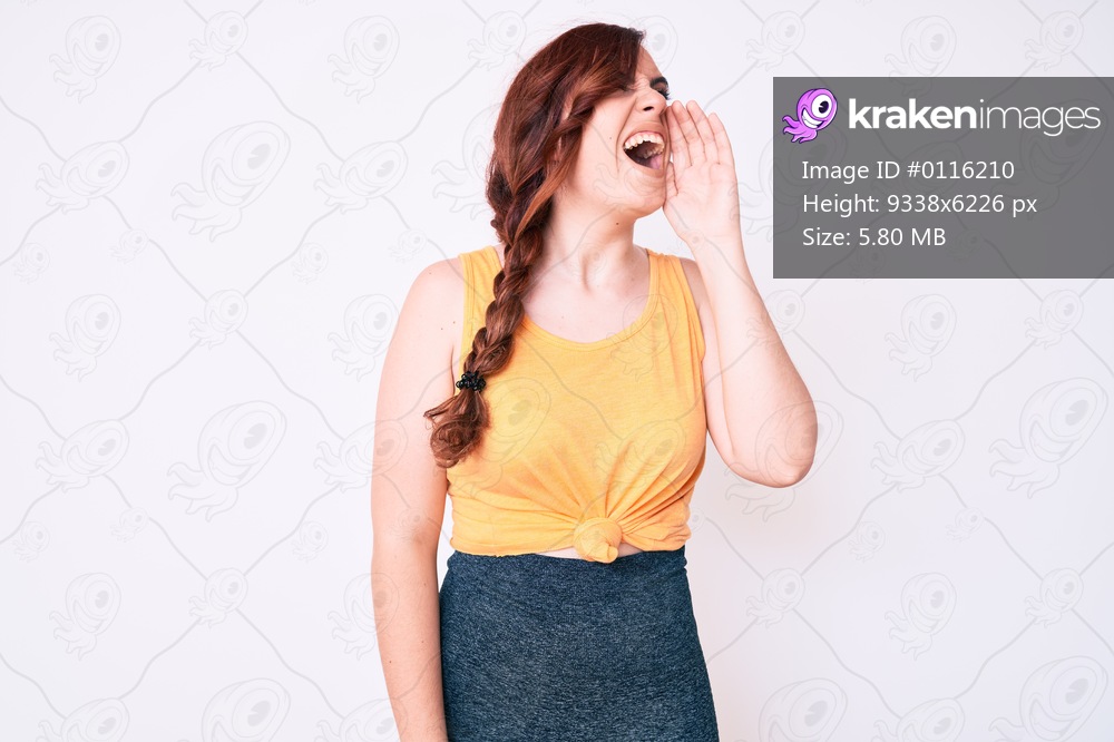 Young beautiful woman wearing casual clothes shouting and screaming loud to side with hand on mouth. communication concept. 