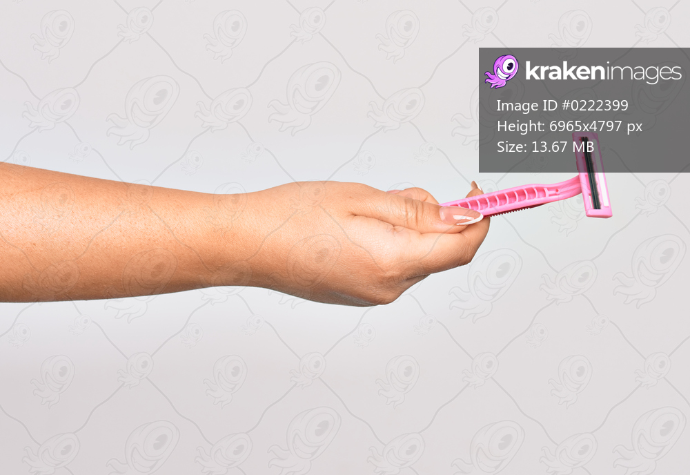 Hand of caucasian young woman holding pink razor over isolated white background