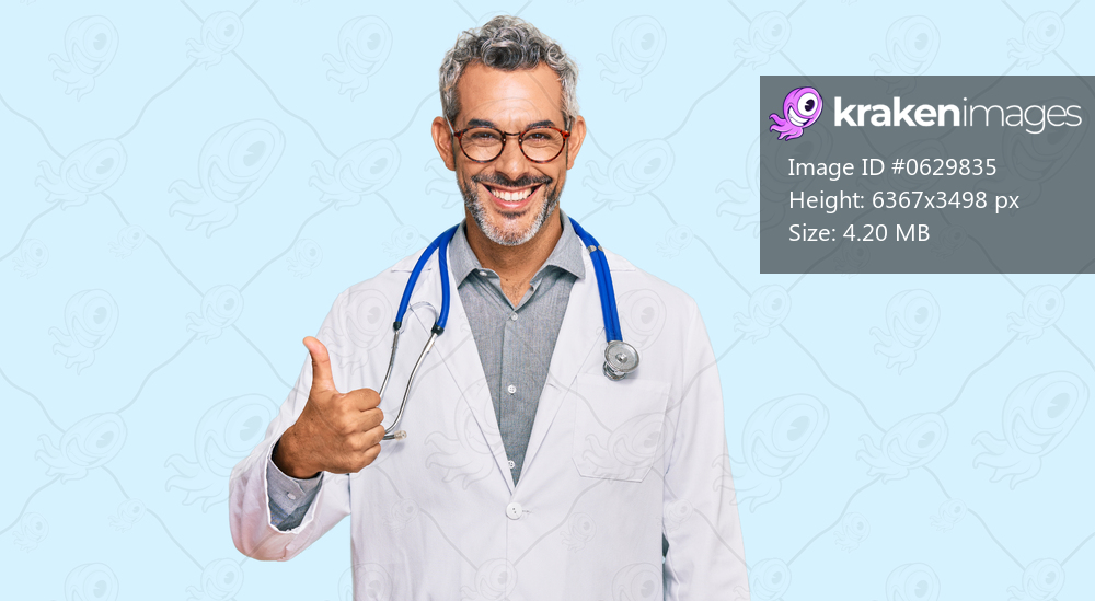 Middle age grey-haired man wearing doctor uniform and stethoscope smiling happy and positive, thumb up doing excellent and approval sign 