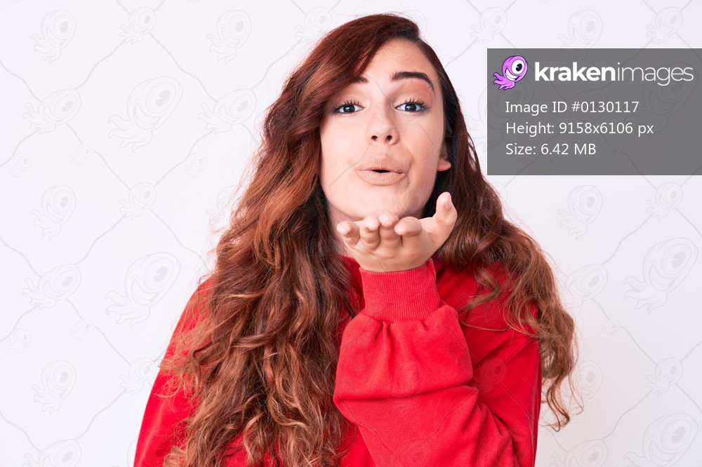 Young beautiful woman wearing casual clothes looking at the camera blowing a kiss with hand on air being lovely and sexy. love expression. 