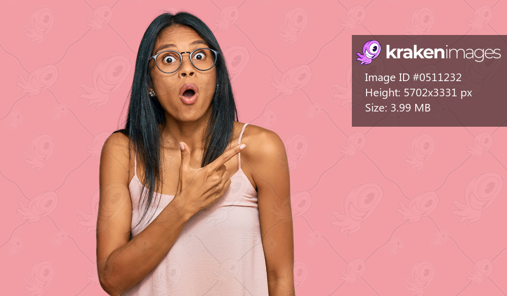 Young african american woman wearing casual clothes and glasses surprised pointing with finger to the side, open mouth amazed expression. 