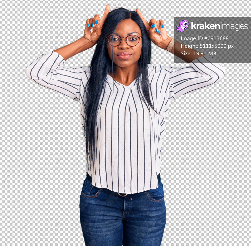 Young african american woman wearing casual clothes and glasses doing funny gesture with finger over head as bull horns