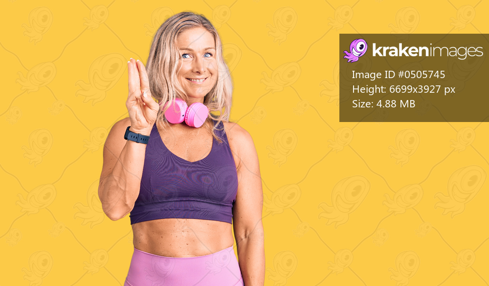 Middle age fit blonde woman wearing gym clothes and using headphones showing and pointing up with fingers number three while smiling confident and happy. 