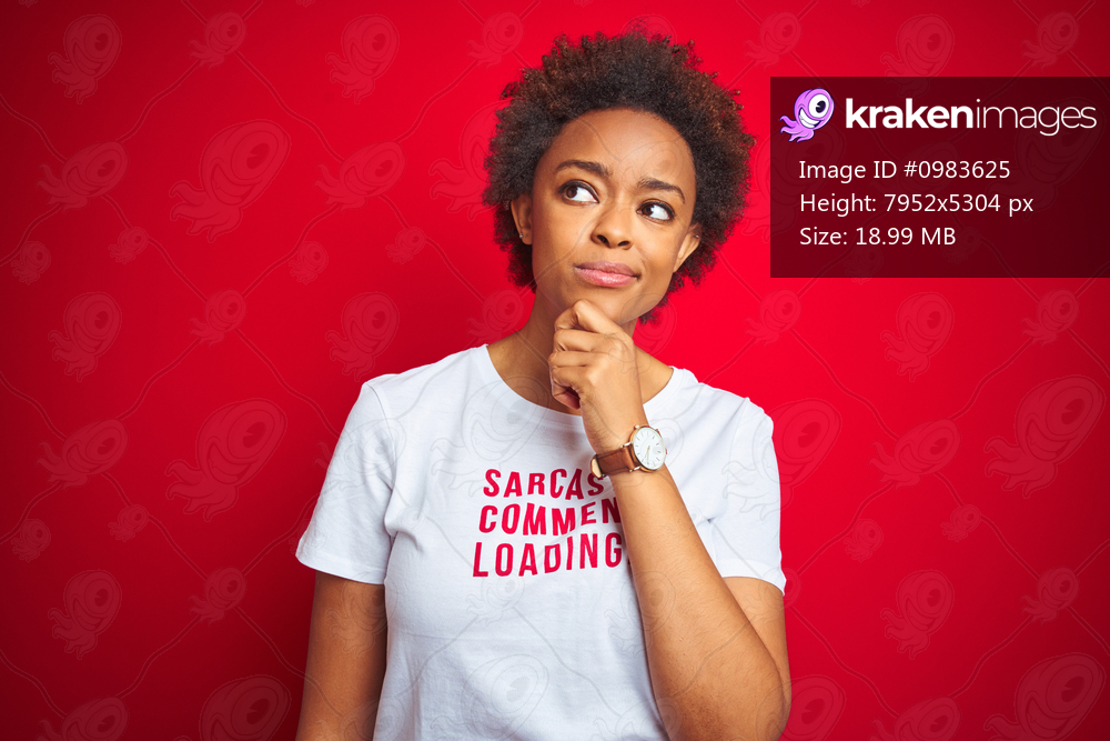 African american woman wearing sarcastic comments t-shirt over red isolated background with hand on chin thinking about question, pensive expression. Smiling with thoughtful face. Doubt concept.