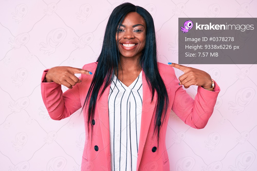 Young african american woman wearing business clothes looking confident with smile on face, pointing oneself with fingers proud and happy. 
