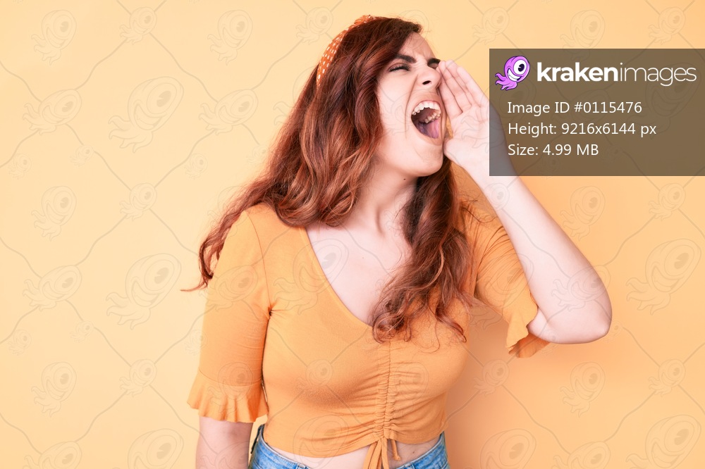 Young beautiful woman wearing casual clothes shouting and screaming loud to side with hand on mouth. communication concept. 
