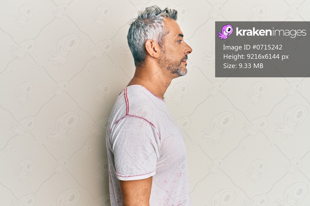 Middle age grey-haired man wearing casual clothes looking to side, relax profile pose with natural face with confident smile. 