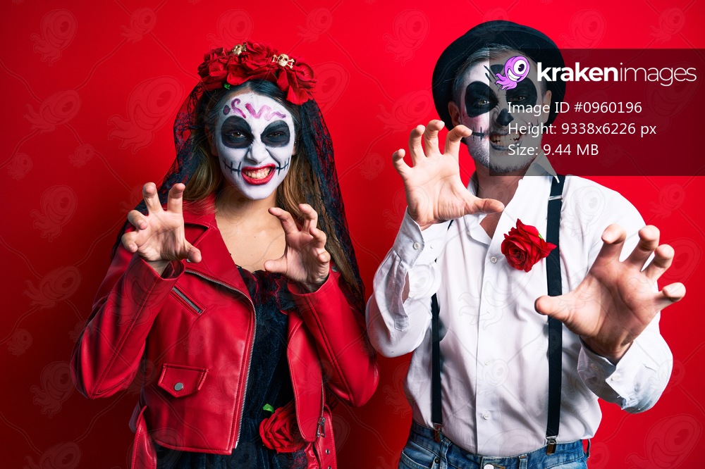 Couple wearing day of the dead costume over red smiling funny doing claw gesture as cat, aggressive and sexy expression 
