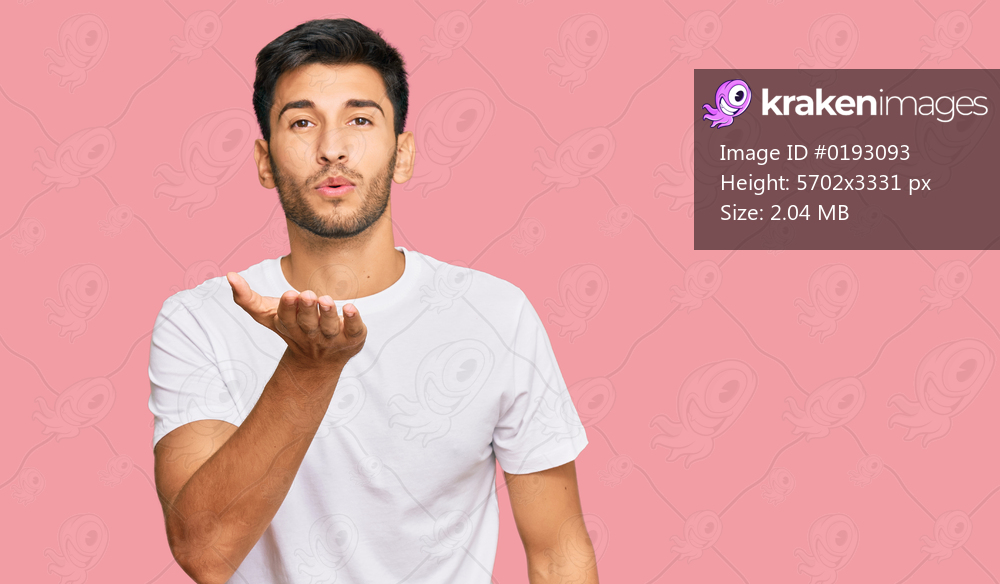 Young handsome man wearing casual white tshirt looking at the camera blowing a kiss with hand on air being lovely and sexy. love expression. 
