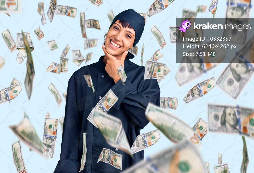 Young brunette woman with short hair wearing professional cook uniform looking confident at the camera smiling with crossed arms and hand raised on chin. thinking positive.