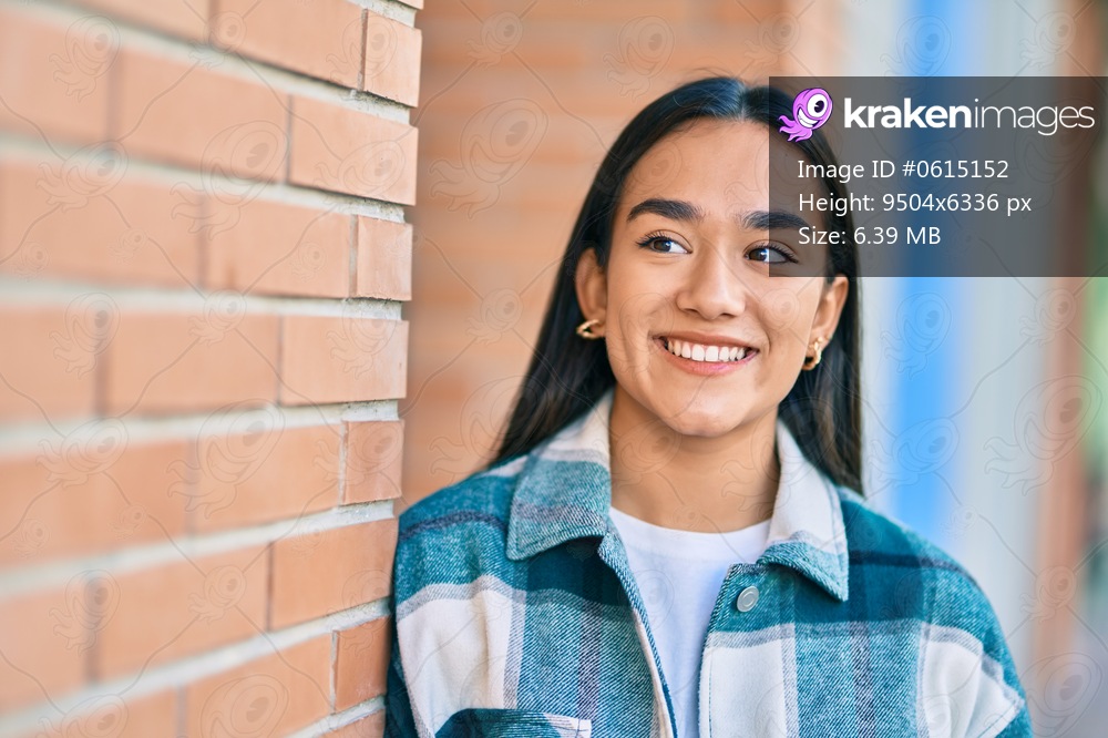 Young latin girl smiling happy standing at the city.
