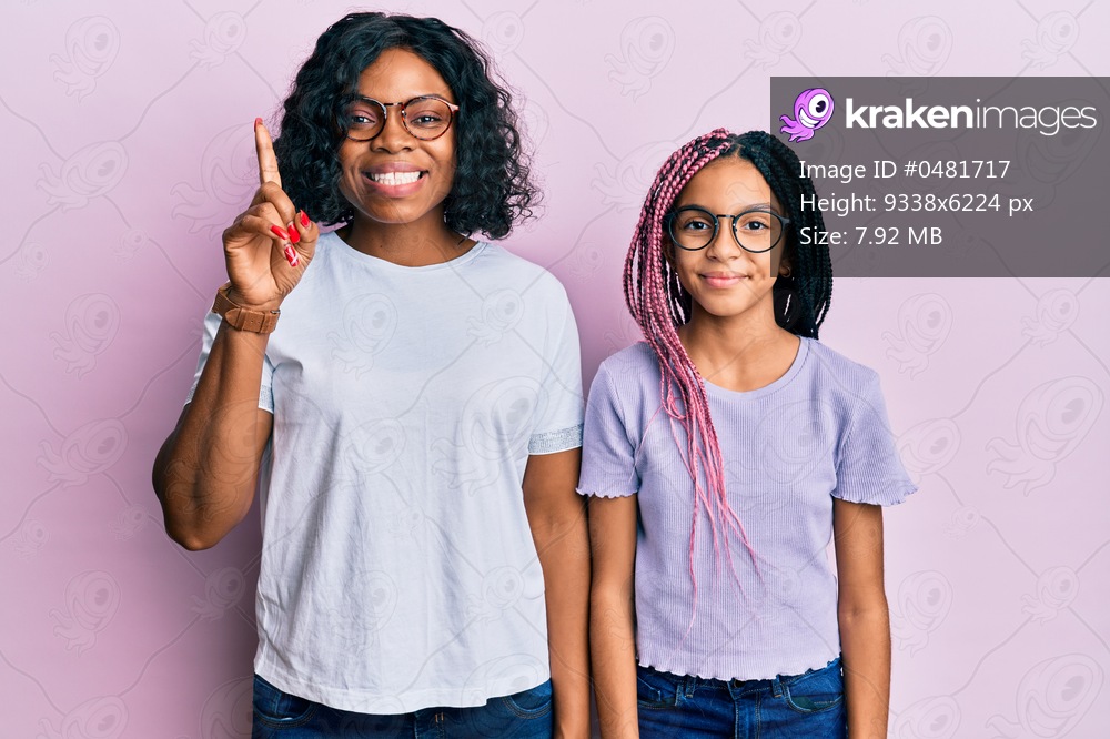 Beautiful african american mother and daughter wearing casual clothes and glasses showing and pointing up with finger number one while smiling confident and happy. 