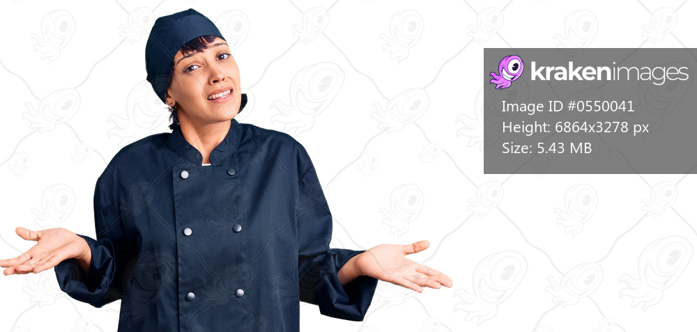 Young brunette woman with short hair wearing professional cook uniform clueless and confused expression with arms and hands raised. doubt concept. 