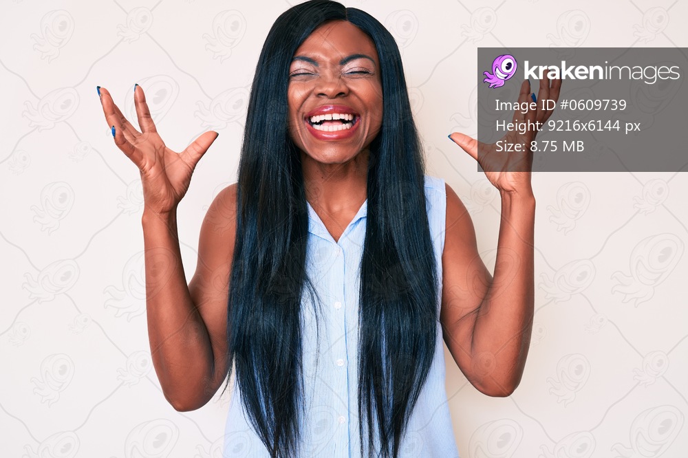 Young african american woman wearing casual clothes celebrating mad and crazy for success with arms raised and closed eyes screaming excited. winner concept 