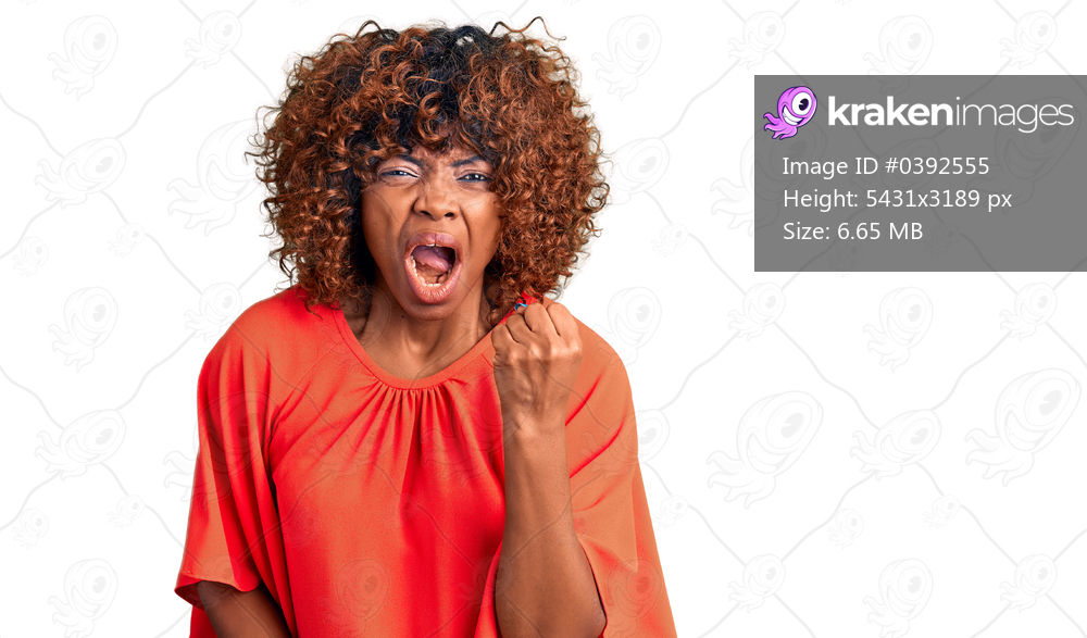 Young african american woman wearing casual clothes angry and mad raising fist frustrated and furious while shouting with anger. rage and aggressive concept. 