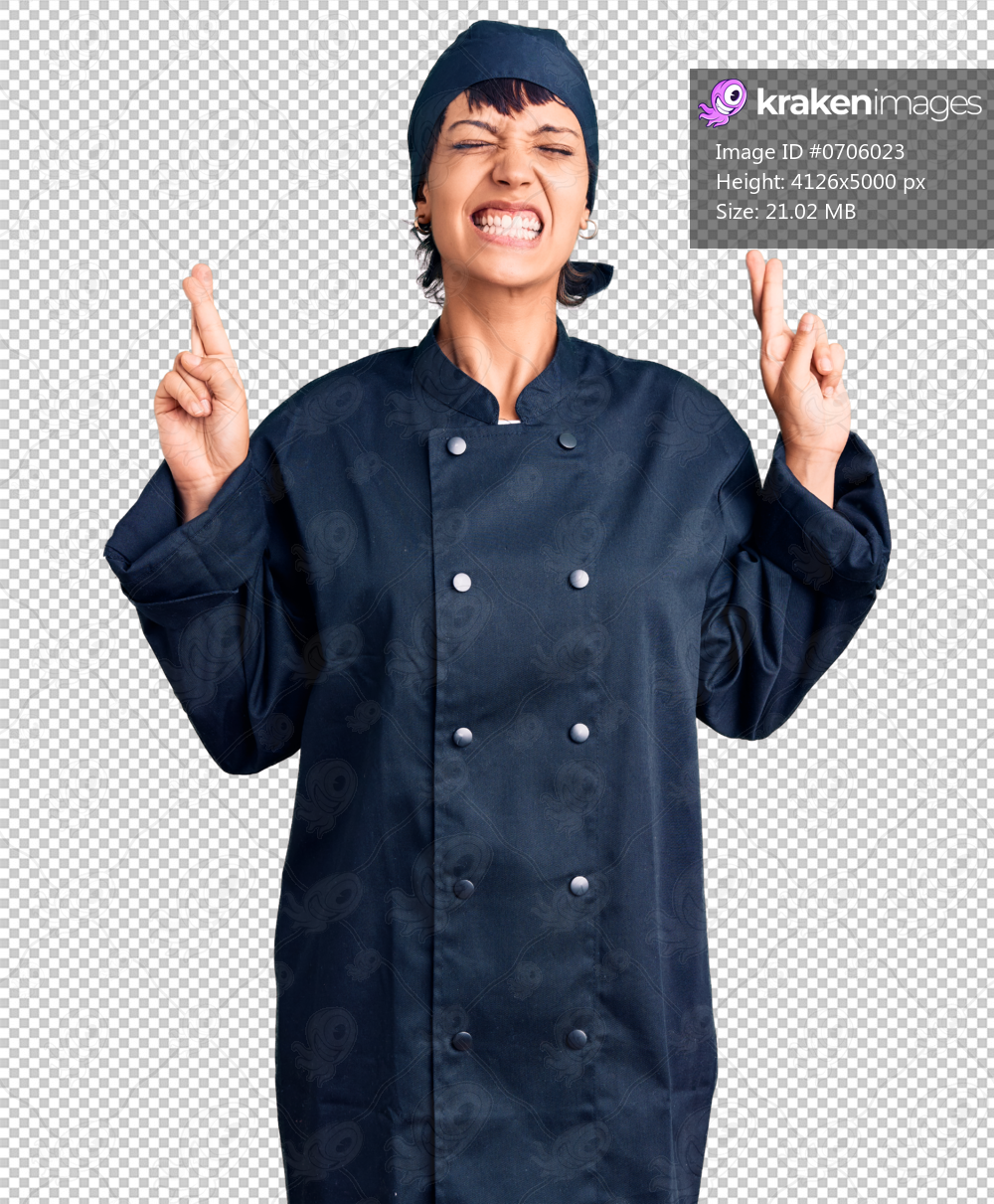 Young brunette woman with short hair wearing professional cook uniform gesturing finger crossed smiling with hope and eyes closed. luck and superstitious concept.