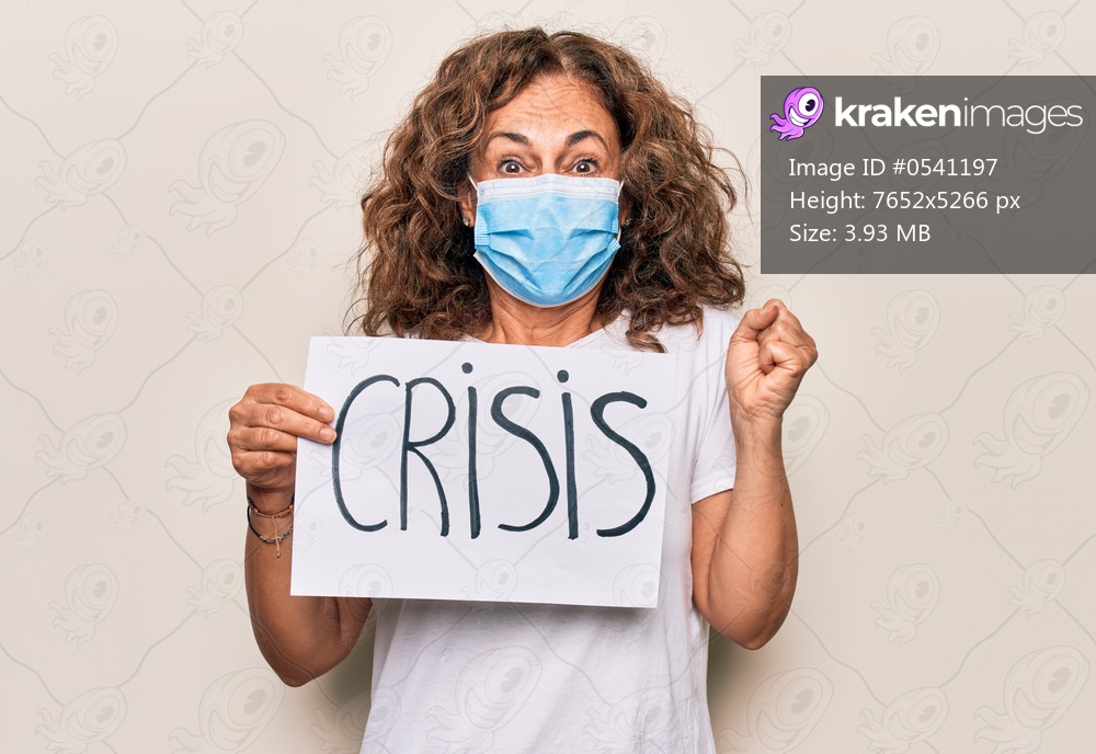 Middle age woman wearing coronavirus protection mask holding epidemic crisis paper as protest screaming proud, celebrating victory and success very excited with raised arm