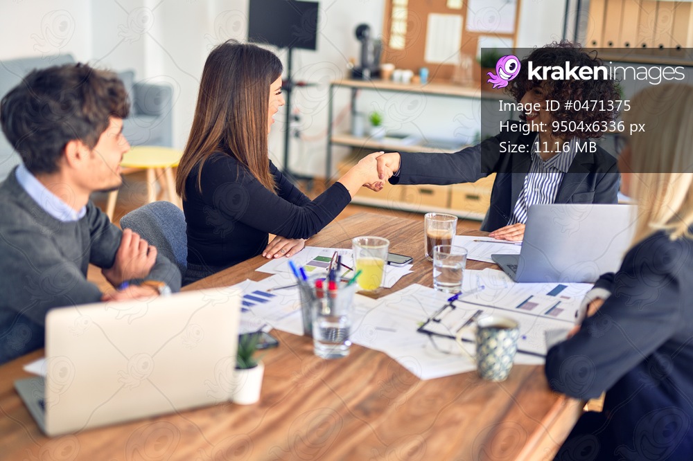Group of business workers smiling happy and confident. Working together with smile on face shaking hands for agreement at the office