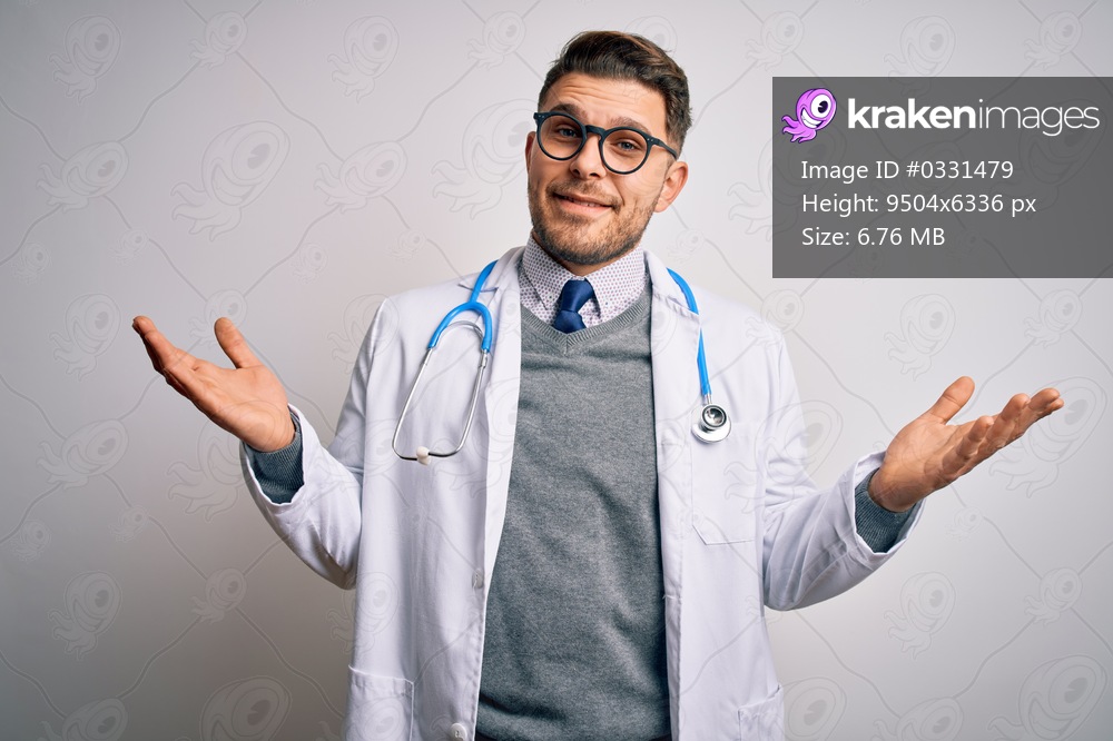 Young doctor man with blue eyes wearing medical coat and stethoscope over isolated background smiling showing both hands open palms, presenting and advertising comparison and balance