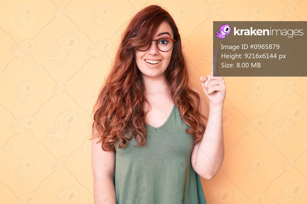 Young beautiful woman wearing casual clothes and glasses pointing finger up with successful idea. exited and happy. number one. 
