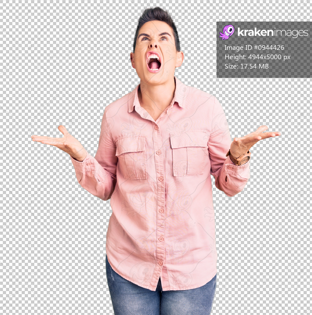 Young woman with short hair wearing casual clothes crazy and mad shouting and yelling with aggressive expression and arms raised. frustration concept.