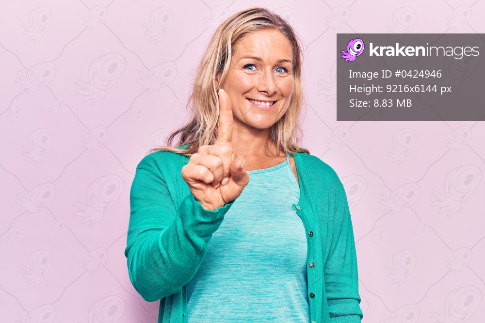 Middle age caucasian blonde woman wearing casual clothes smiling with an idea or question pointing finger up with happy face, number one 