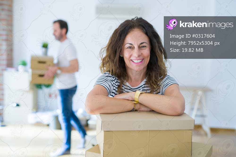 Middle age senior couple moving to a new house, woman smiling happy in love with new apartment