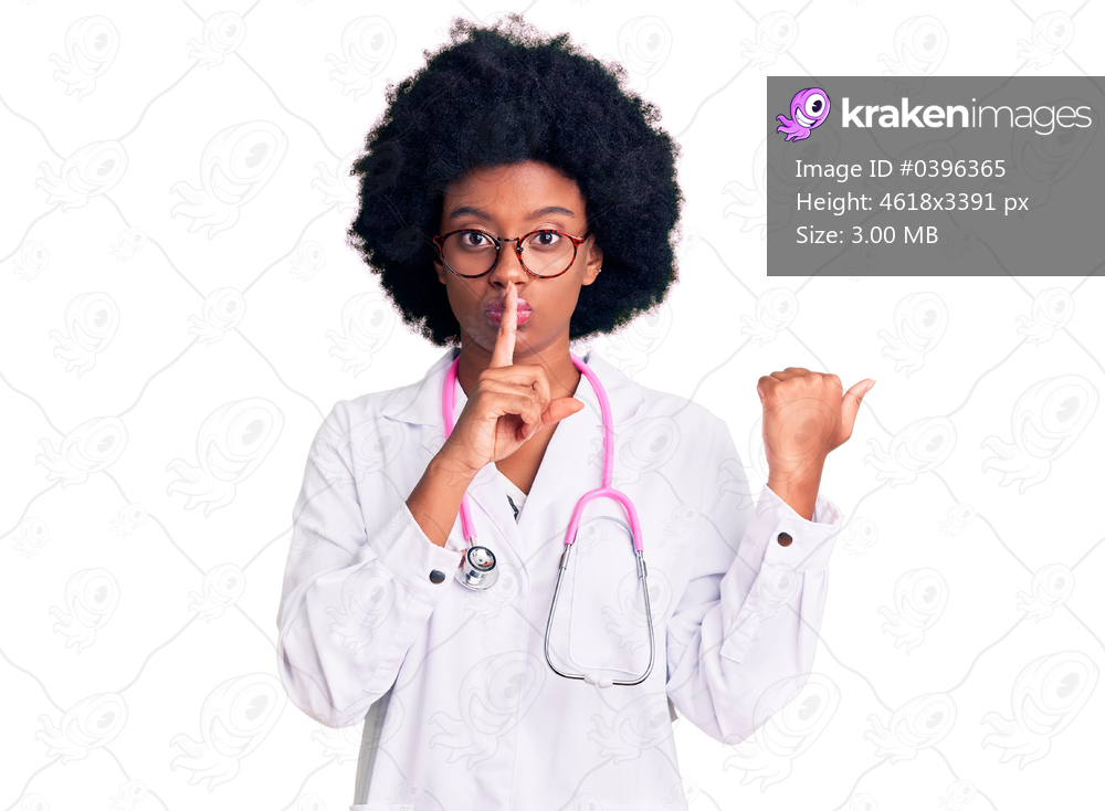Young african american woman wearing doctor coat and stethoscope asking to be quiet with finger on lips pointing with hand to the side. silence and secret concept. 
