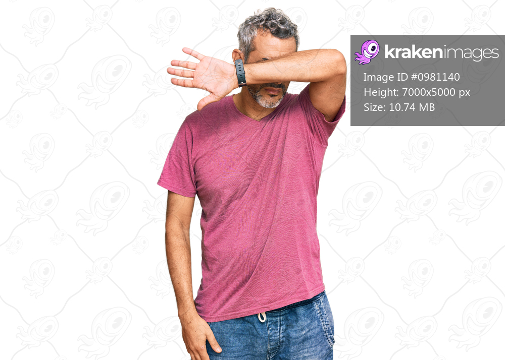 Middle age grey-haired man wearing casual clothes covering eyes with arm, looking serious and sad. sightless, hiding and rejection concept 