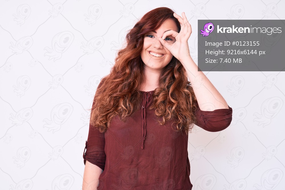 Young beautiful woman wearing casual clothes smiling happy doing ok sign with hand on eye looking through fingers 