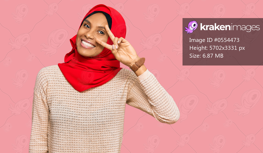 Young african american woman wearing traditional islamic hijab scarf doing peace symbol with fingers over face, smiling cheerful showing victory 