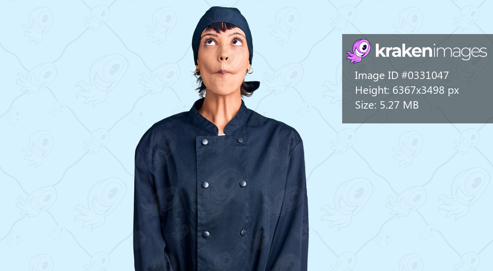 Young brunette woman with short hair wearing professional cook uniform making fish face with lips, crazy and comical gesture. funny expression. 