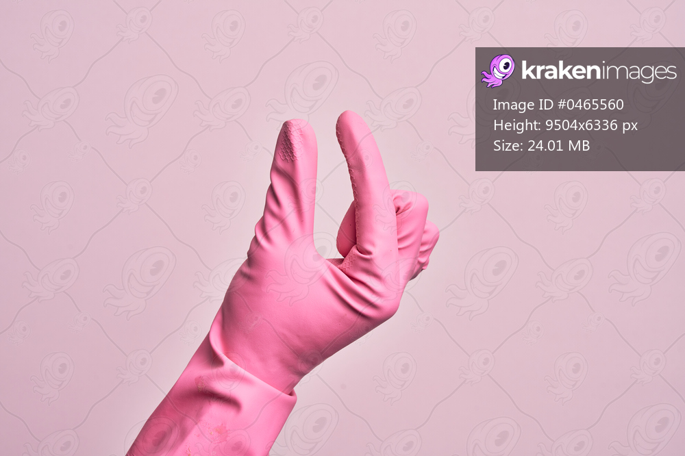 Hand of caucasian young man with cleaning glove over isolated pink background picking and taking invisible thing, holding object with fingers showing space