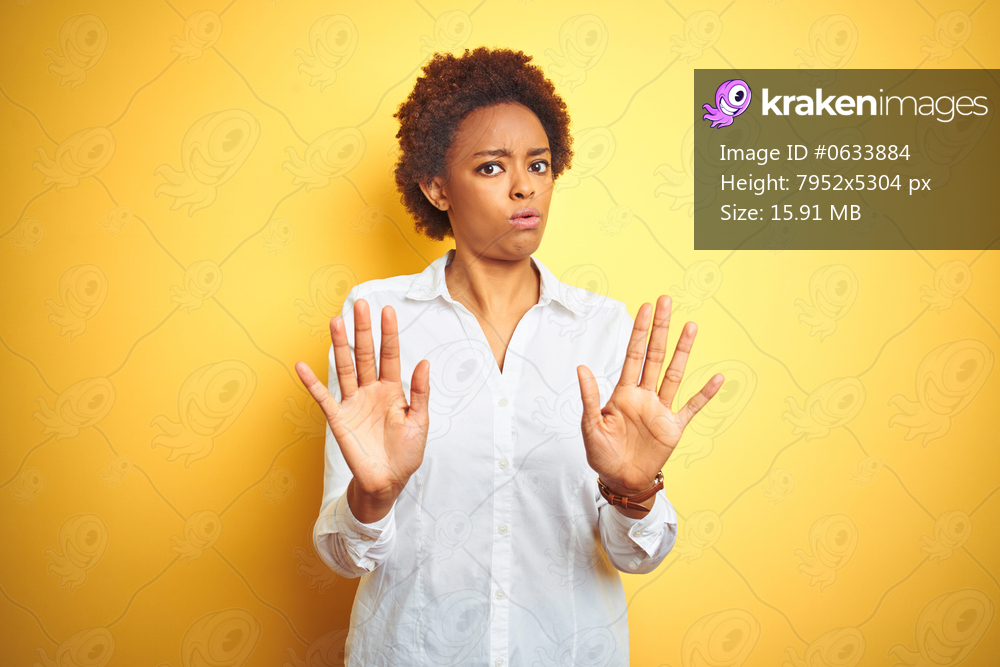 African american business woman over isolated yellow background Moving away hands palms showing refusal and denial with afraid and disgusting expression. Stop and forbidden.