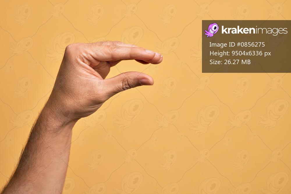 Hand of caucasian young man showing fingers over isolated yellow background picking and taking invisible thing, holding object with fingers showing space