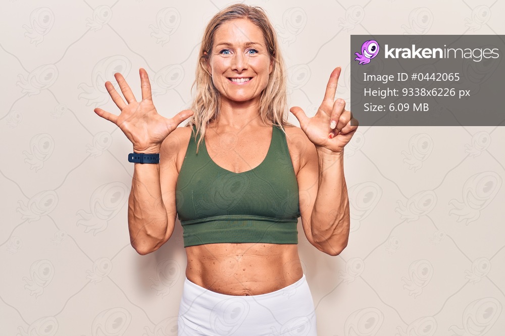 Middle age caucasian blonde woman wearing sportswear showing and pointing up with fingers number seven while smiling confident and happy. 