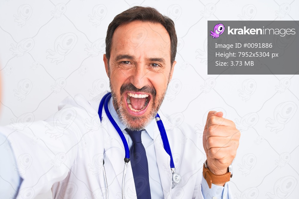 Middle age doctor man wearing stethoscope make selfie over isolated white background screaming proud and celebrating victory and success very excited, cheering emotion