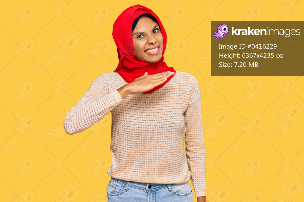 Young african american woman wearing traditional islamic hijab scarf cutting throat with hand as knife, threaten aggression with furious violence 