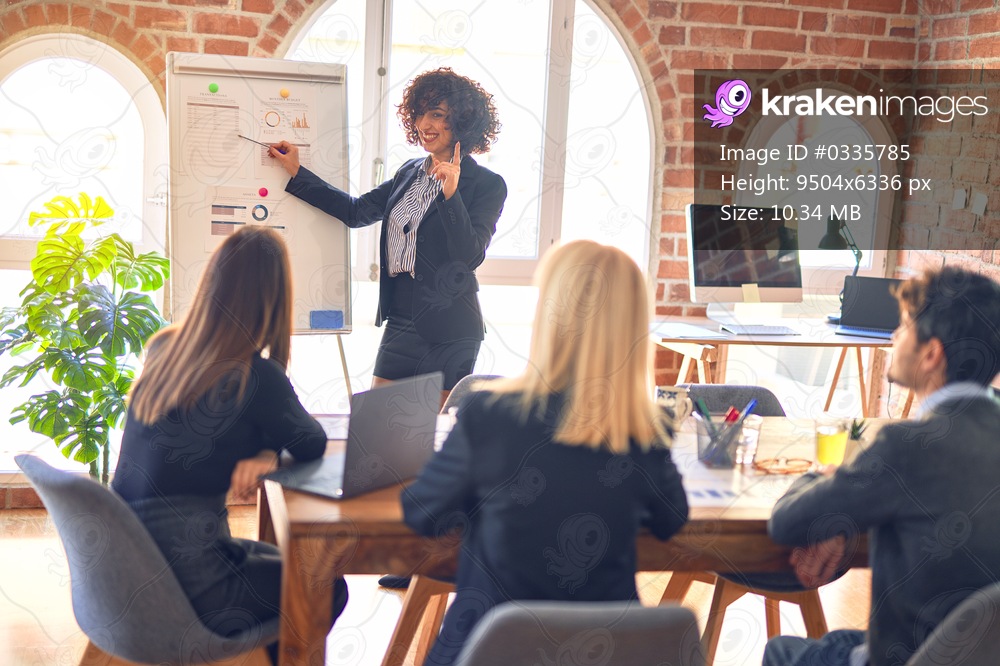 Group of business workers working together in a meeting. One of them making presentation to colleagues at the office