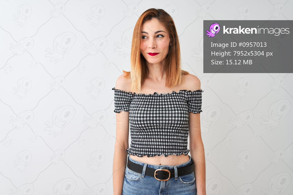 Beautiful redhead woman wearing casual t-shirt standing over isolated white background smiling looking to the side and staring away thinking.