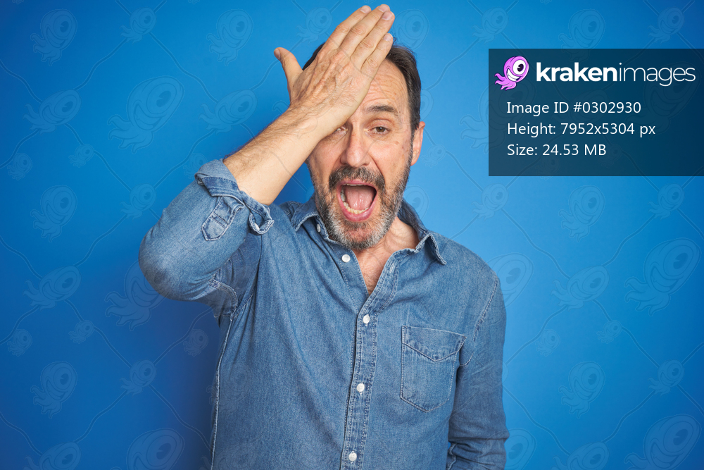 Handsome middle age senior man with grey hair over isolated blue background surprised with hand on head for mistake, remember error. Forgot, bad memory concept.