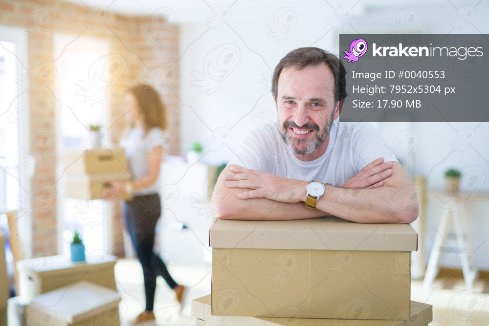 Middle age senior couple moving to a new house, man smiling happy in love with new apartment