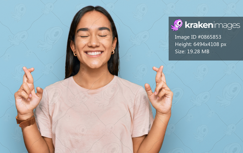 Young asian woman wearing casual clothes gesturing finger crossed smiling with hope and eyes closed. luck and superstitious concept. 