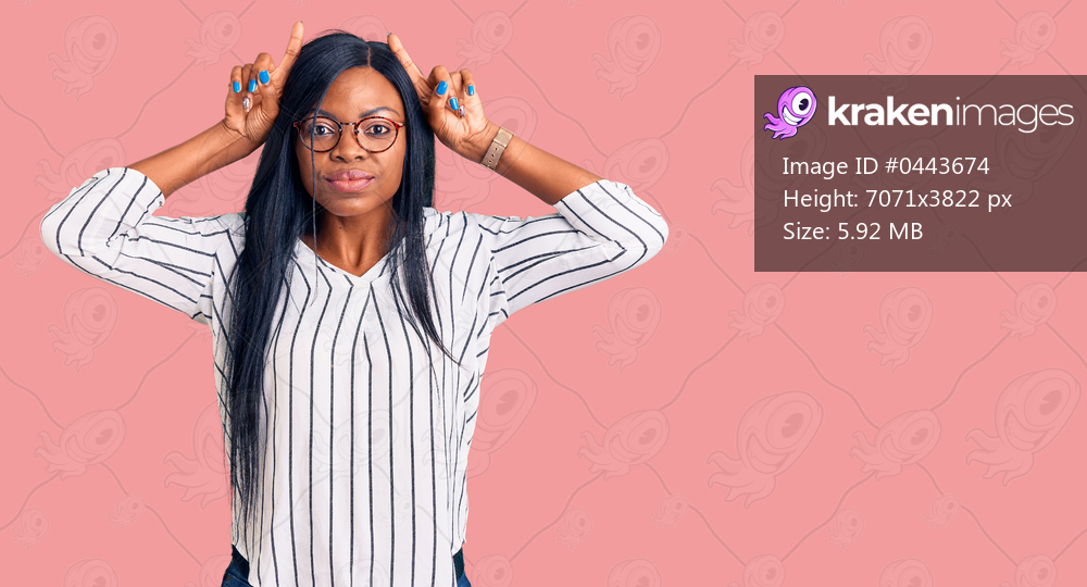 Young african american woman wearing casual clothes and glasses doing funny gesture with finger over head as bull horns 