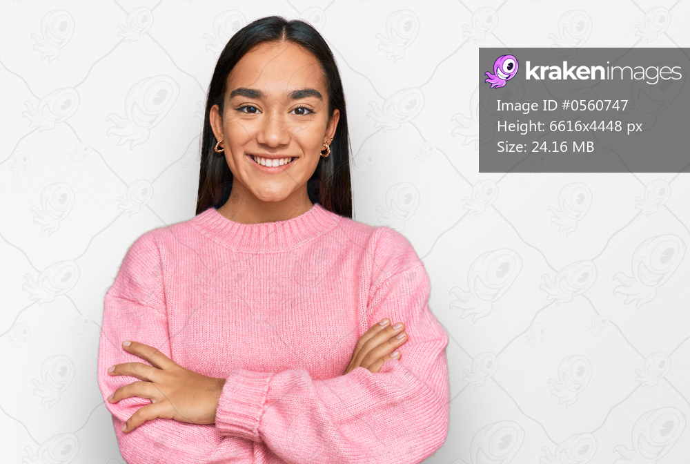 Young asian woman wearing casual winter sweater happy face smiling with crossed arms looking at the camera. positive person. 