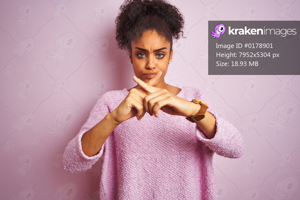 Young african american woman wearing winter sweater standing over isolated pink background Rejection expression crossing fingers doing negative sign