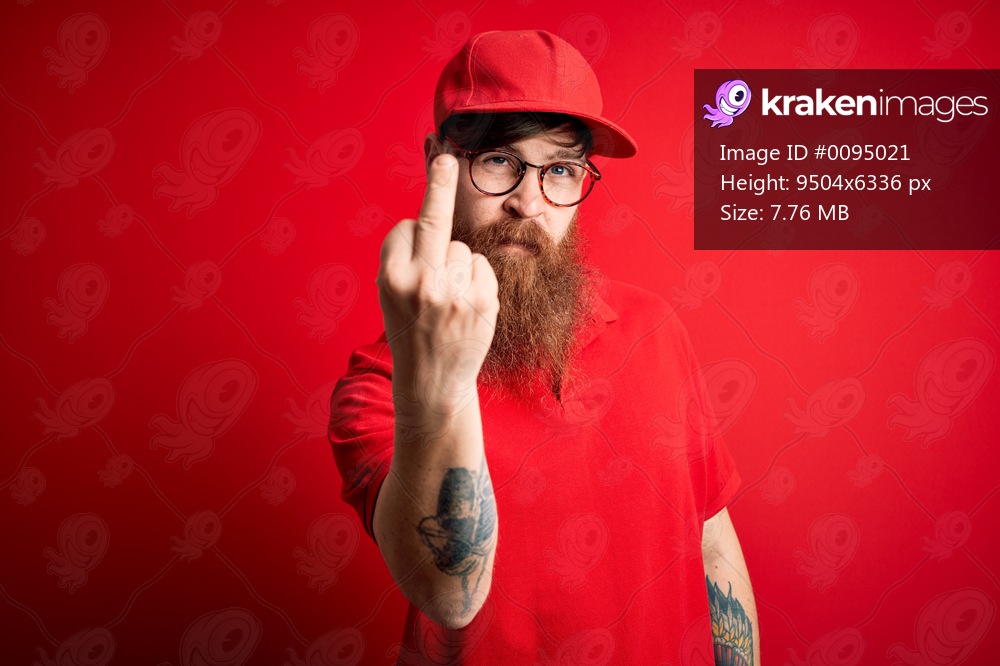 Young handsome delivery man wearing glasses and red cap over isolated background Showing middle finger, impolite and rude fuck off expression