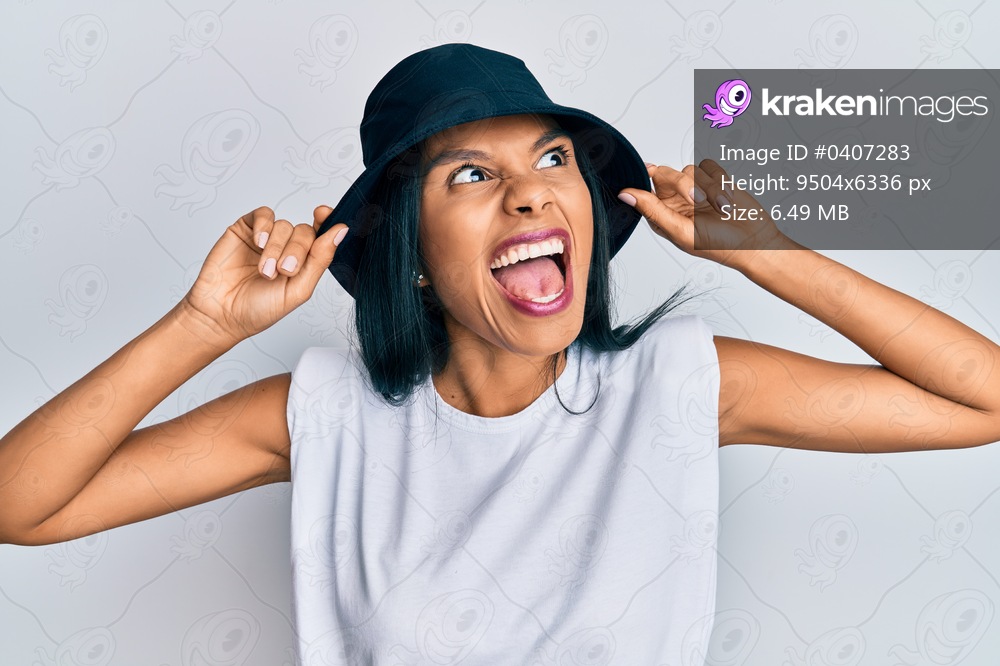 Young african american woman wearing fashion hat angry and mad screaming frustrated and furious, shouting with anger. rage and aggressive concept. 